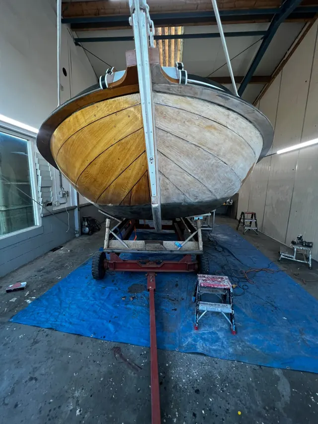 Houten bootromp half geschuurd, half gelakt