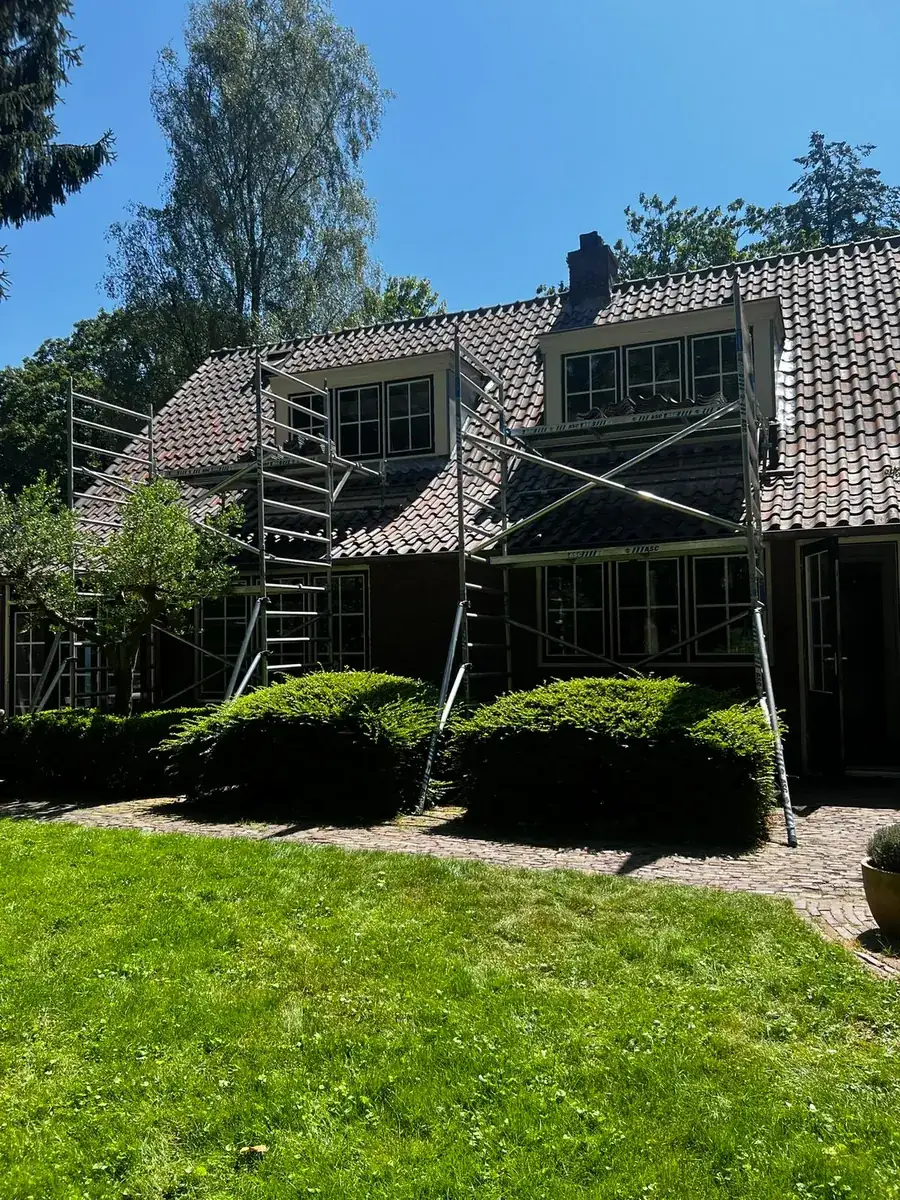 Woning met steigers bij de dakkapellen voor buitenschilderwerk